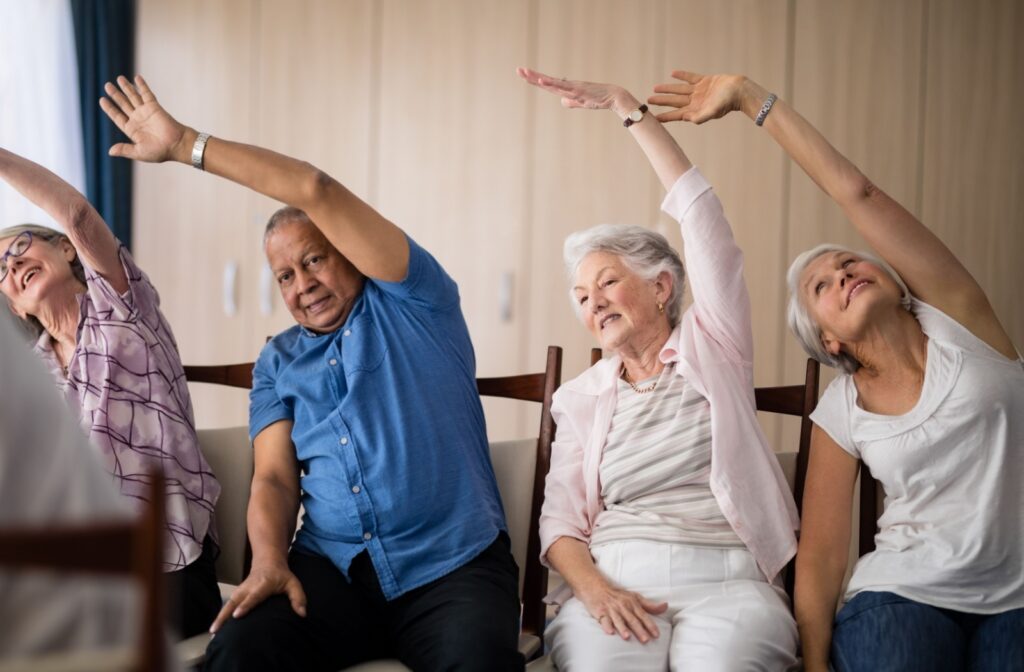 A group of seniors, each stretching one arm over their head.